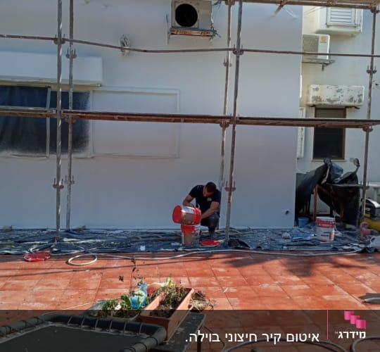 פיגומים, פועל עם דלי צבע, קיר צבוע, צינורות על הרצפה